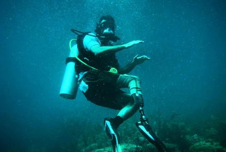 A scuba diver with a prosthetic leg underwater exploring the ocean.