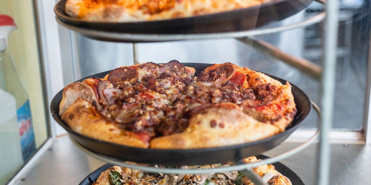 Three pizzas kept at the stand in a safe