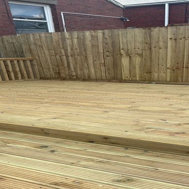 Newly built wooden deck with a privacy fence in a backyard.