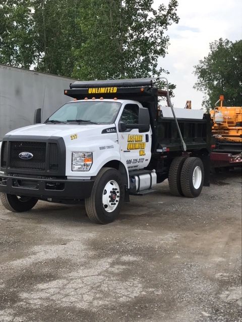 A black and white Asphalt Unlimited Inc., truck