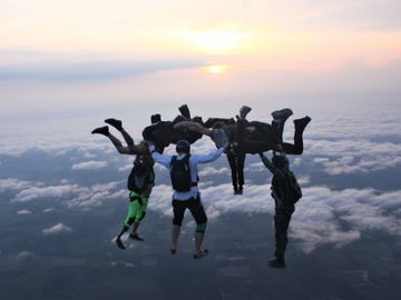Experienced skydivers make a hybrid formation at sunset at Skydive Panama City.