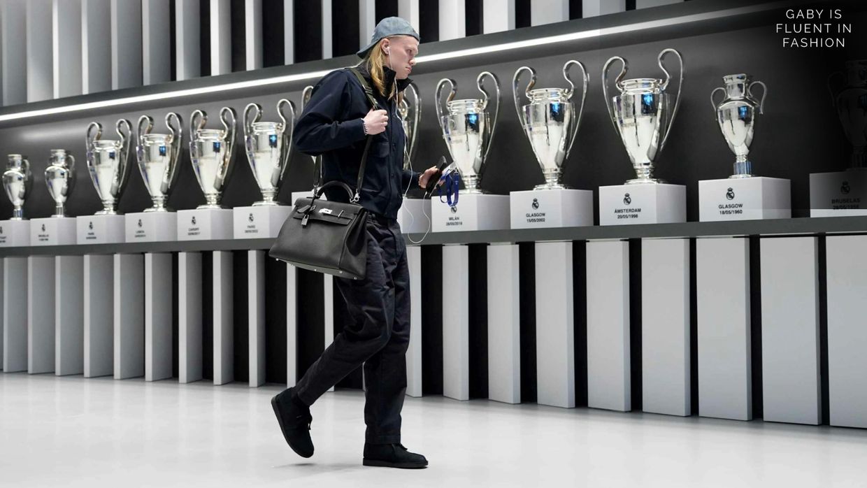 Person walking past a display of trophies.