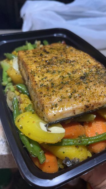 Grilled Salmon over a bed of seasoned yellow rice with veggie medley. 