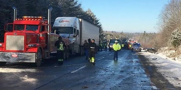Emergency responders at a highway scene with trucks after an incident.