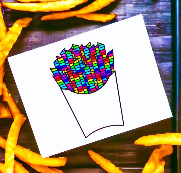 Colorful pixelated fries illustration on paper surrounded by real fries.