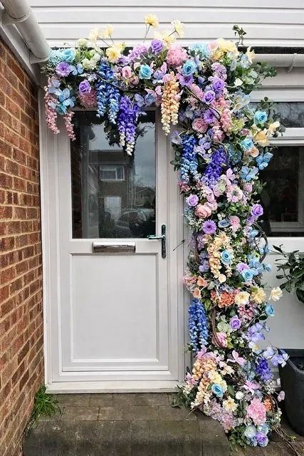 Colorful floral arrangement around a white door.