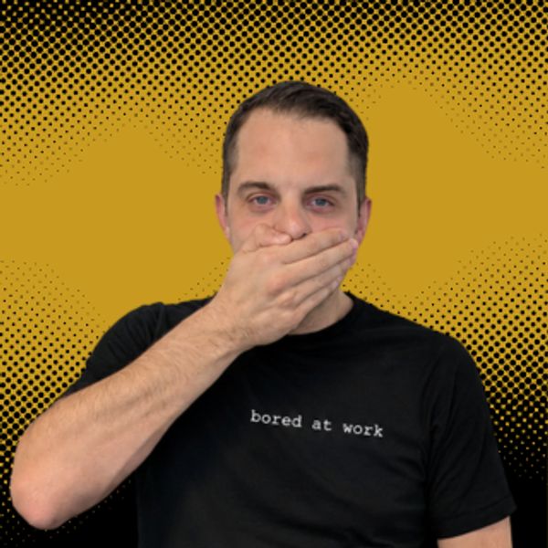 Man covering his mouth, wearing a 'bored at work' shirt.