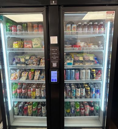 A well-stocked refrigerated display with drinks and snacks.