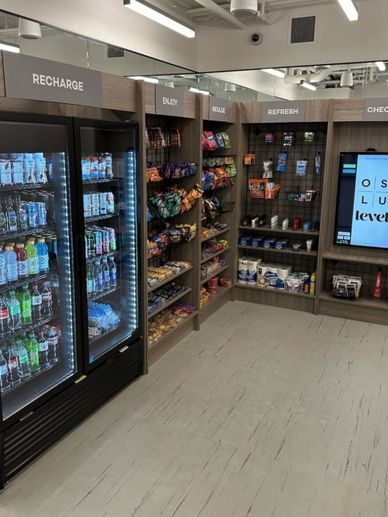 A modern snack and beverage corner with organized sections and illuminated coolers.