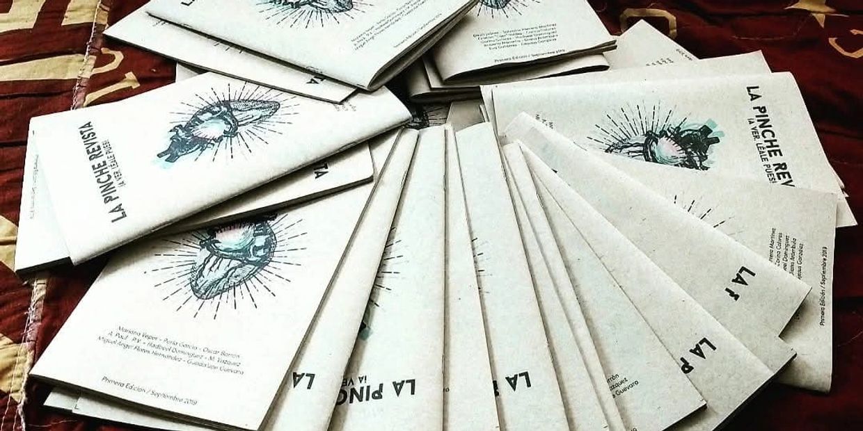 Libros apilados con título 'LA PINCHE REVISTA'.