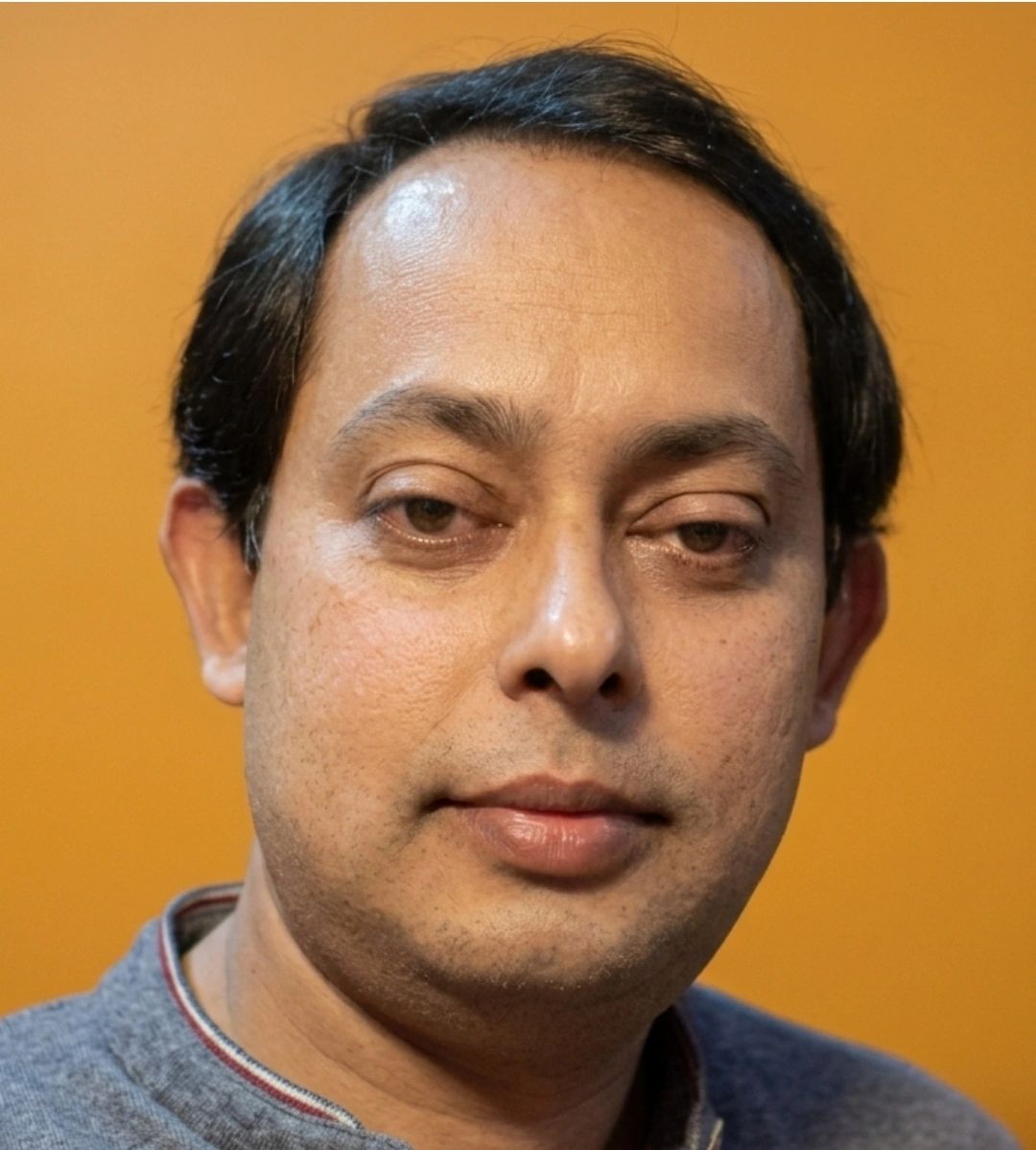 Portrait of a man with a neutral expression.