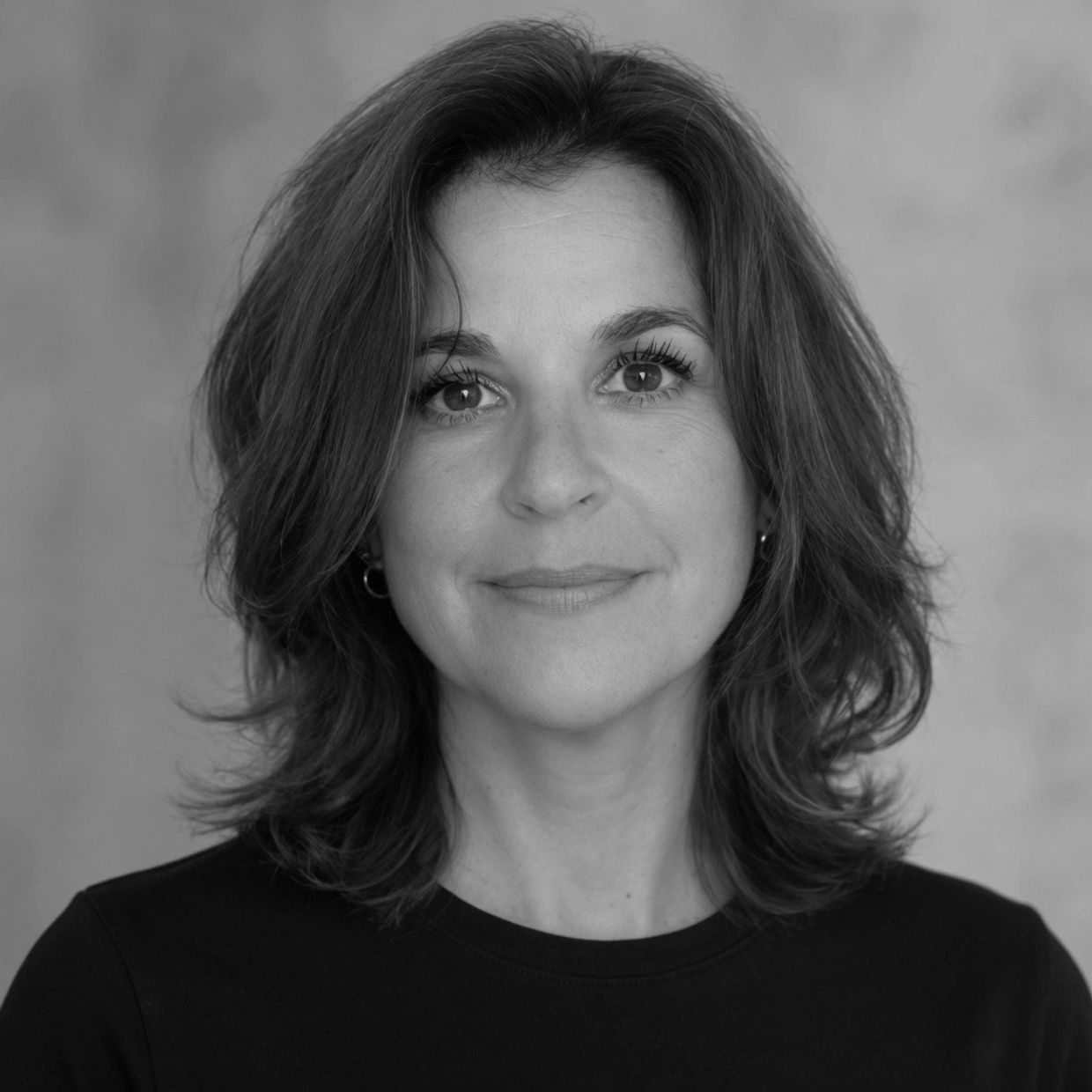 Black and white portrait of a smiling woman with medium-length hair.