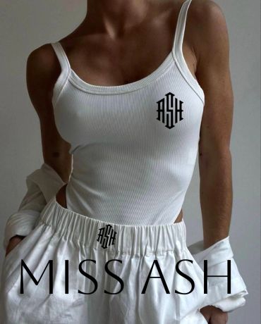 Fashion model wearing a white outfit with 'ASH' logo.