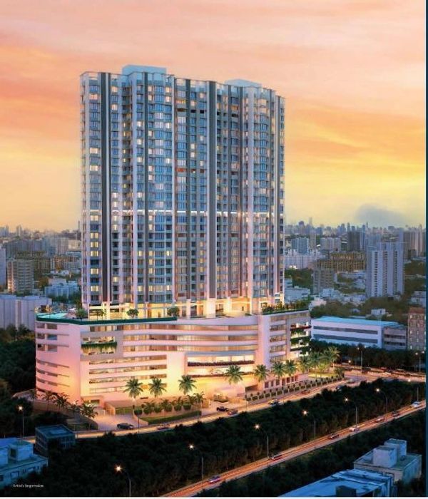 A tall, modern building illuminated at sunset.