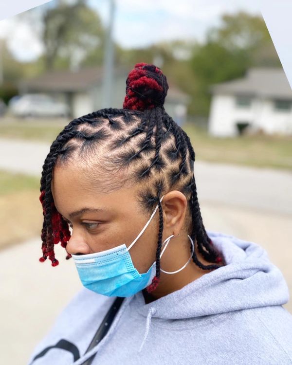 Woman with braided hair and red highlights wearing a blue face mask.