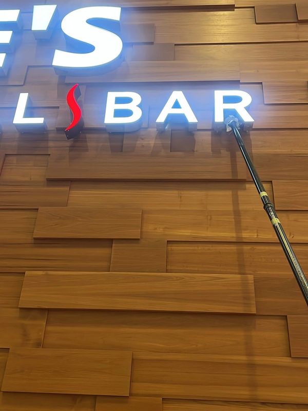 A wooden wall with illuminated letters spelling 'LS BAR' and a red flame design.