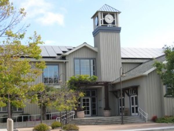 Building with a clock tower and surrounding trees.