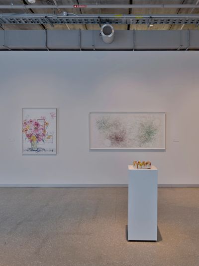 Modern art gallery with abstract and floral artworks displayed on white walls.
