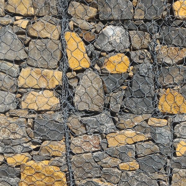 Stacked yellow and gray stones held by wire mesh.