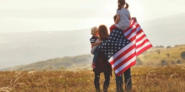 Stock photo of family draped in American flag