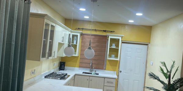 Modern kitchen with white cabinets and marble countertop.