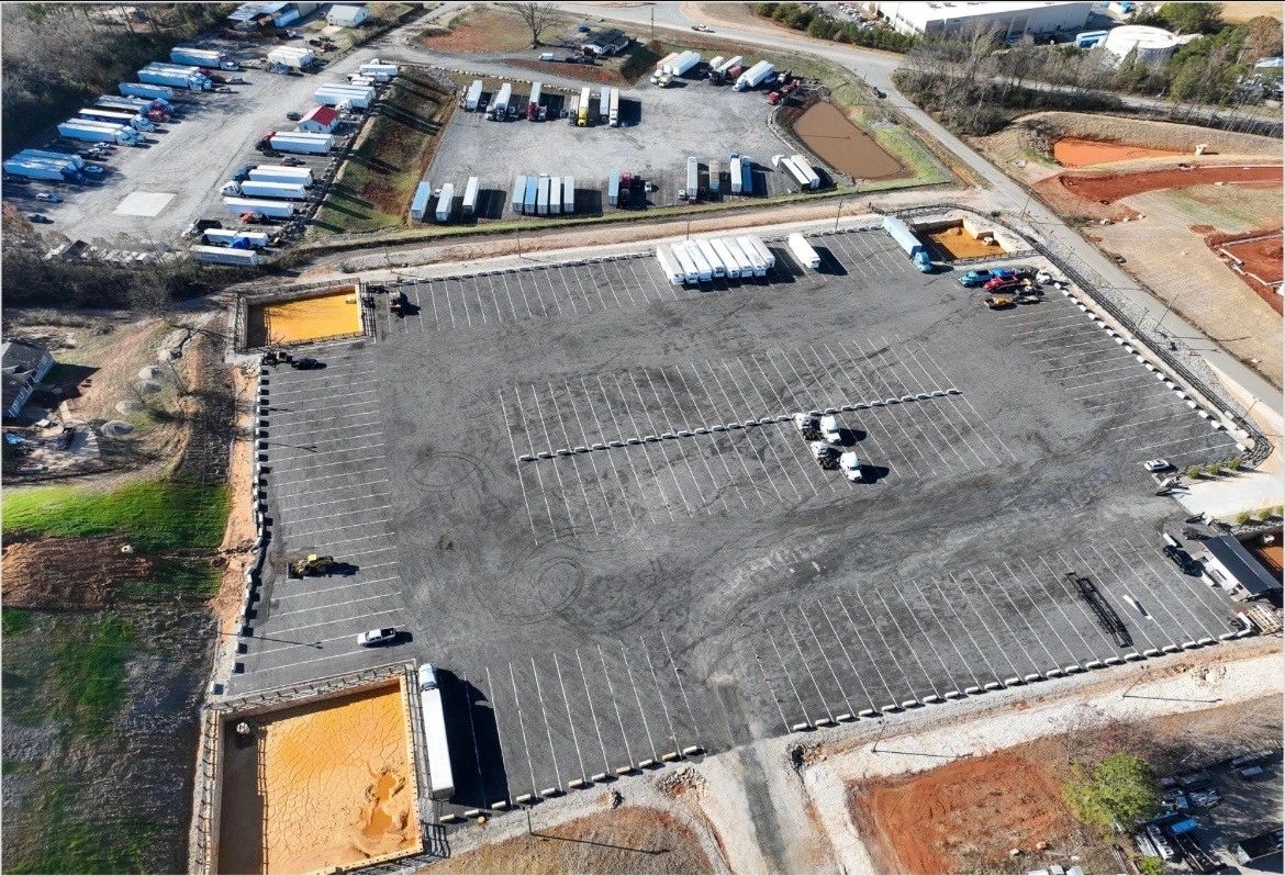 A large parking lot with trucks and trailers parked around the edges.