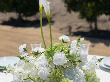 Elegant white and green silk centerpiece rental on a wedding guest table at the Swanner House wedding and event venue in Orange County Ca.