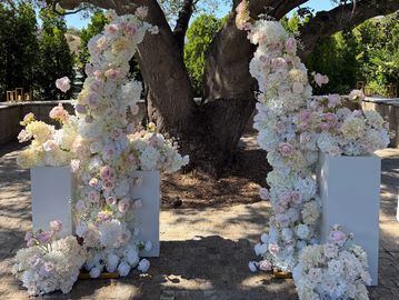 Elegant pink silk floral ceremony decor by a large tree at Dove Canyon by Wedgewood weddings in Orange County, CA.