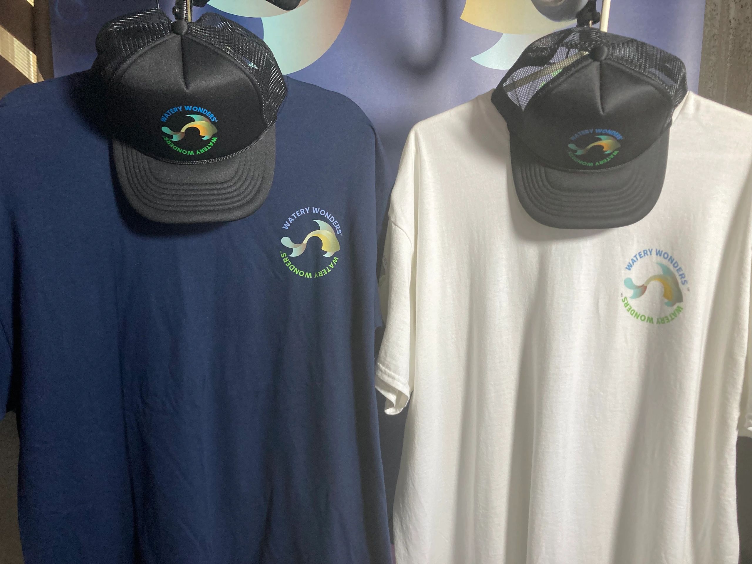 Watery Wonders t-shirts, blue and black. Watery Wonders black trucker hat.