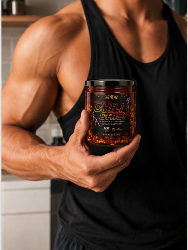 Muscular man holding a jar of chili crisp sauce.