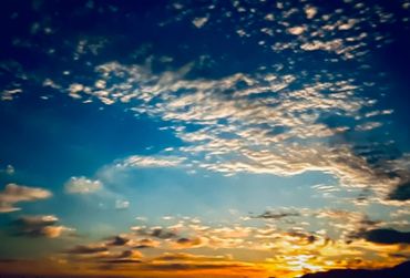 Quiet evening scene with scattered clouds in a glowing horizon