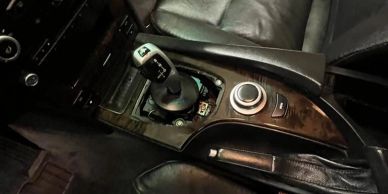 Close-up of a car's gear shift and control knob.