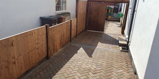 New fencing and gate and grey riven 600×600 slabs 