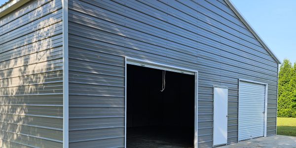 Metal garage with open and closed doors on a sunny day.
