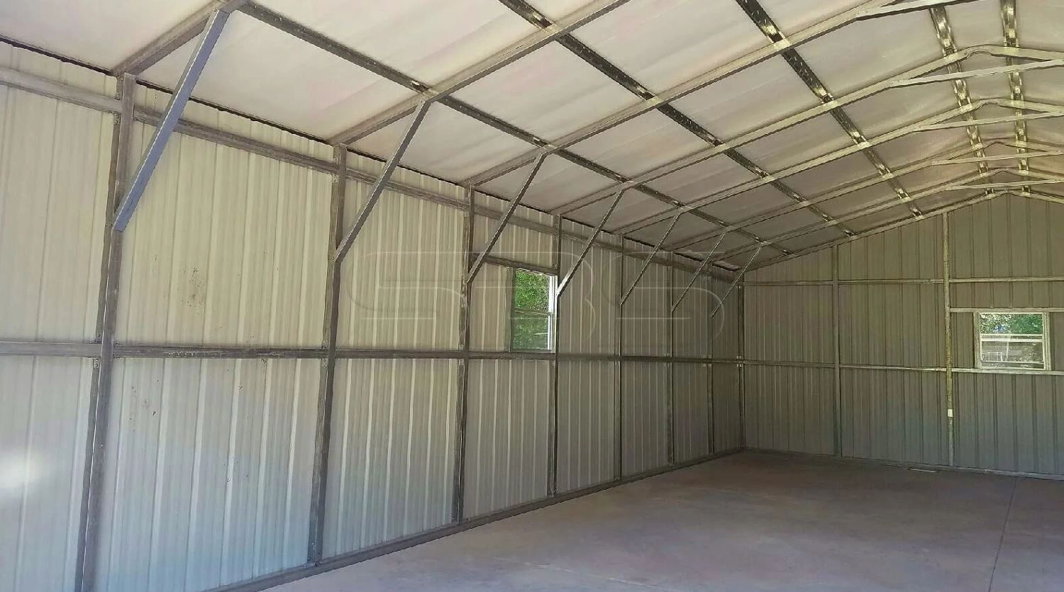 Empty metal shed interior with windows.