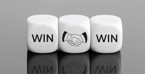 Three white dice showing WIN, handshake, WIN on a reflective surface.