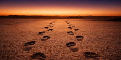 Two sets of footprints in the sand signifies "you are not alone."