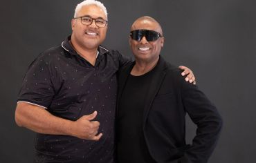 Two men posing and smiling together.