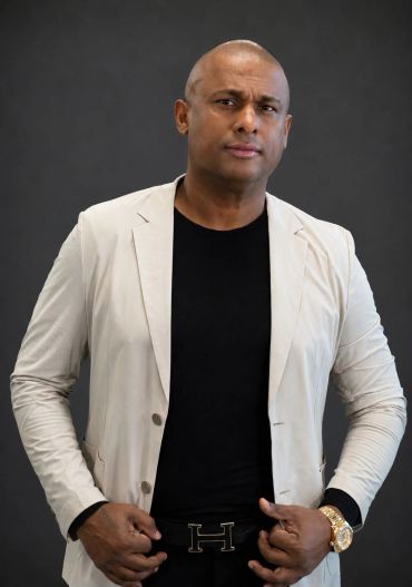 Confident man in beige blazer and black shirt.