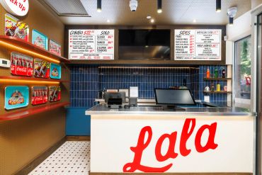 Modern pizza counter with vibrant design and menu boards.