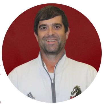 Smiling man in a white jacket with a horse logo.