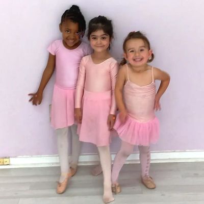 three smiling young ballet dancers