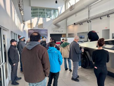 People wait inside a Tesla showroom with a Cybertruck on display.