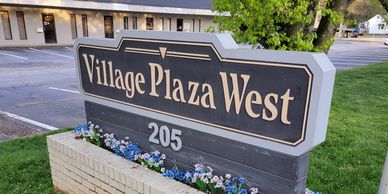 Sign for Village Plaza West with the address 205.
