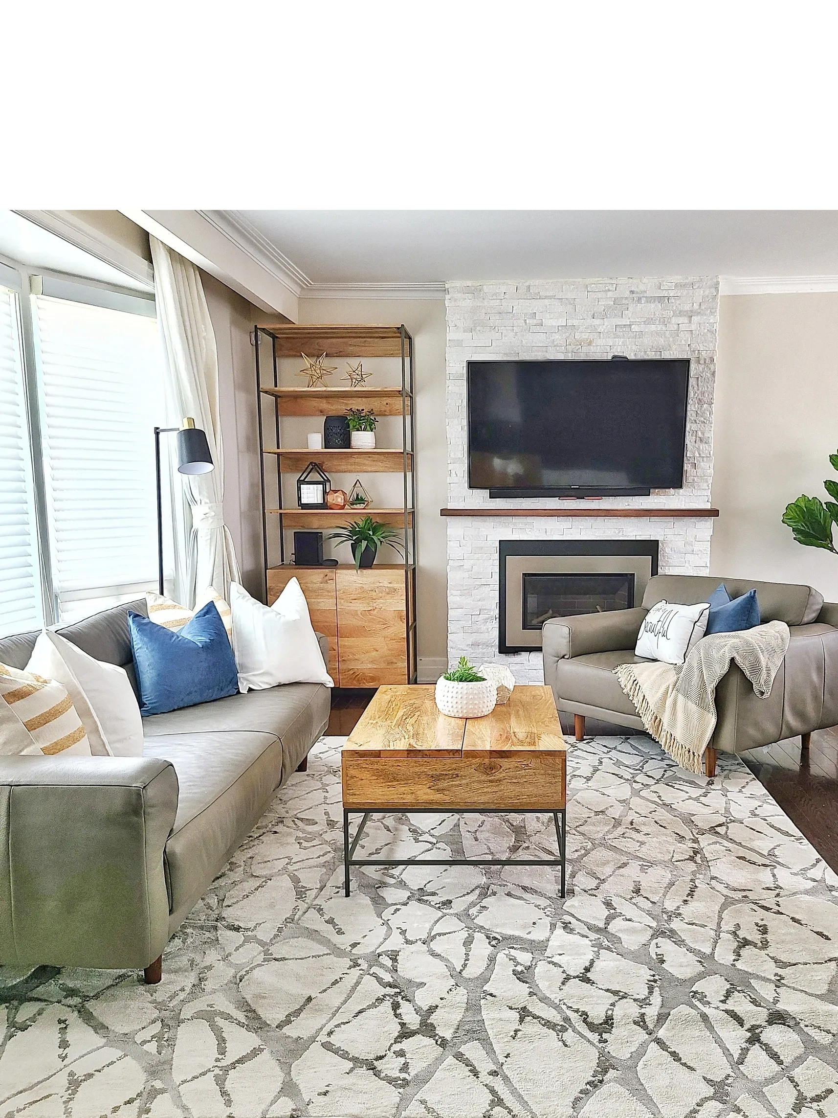 living room with cream rug. mid century modern furniture.  TV over fireplace.