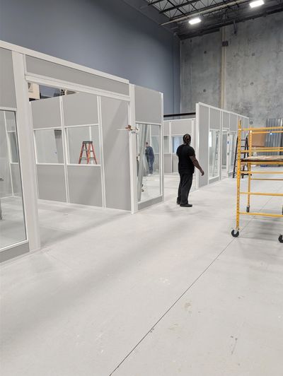 A newly constructed grey modular office building with several windows and large double doors, by SoF