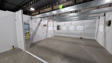 Interior view of a modular office under construction, showing partially installed light grey wall pa