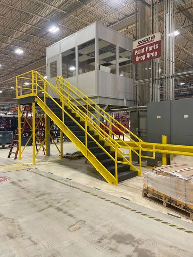 A new grey modular office building on top of a mezzanine, set of yellow stairs. Built by SoFlo Insta