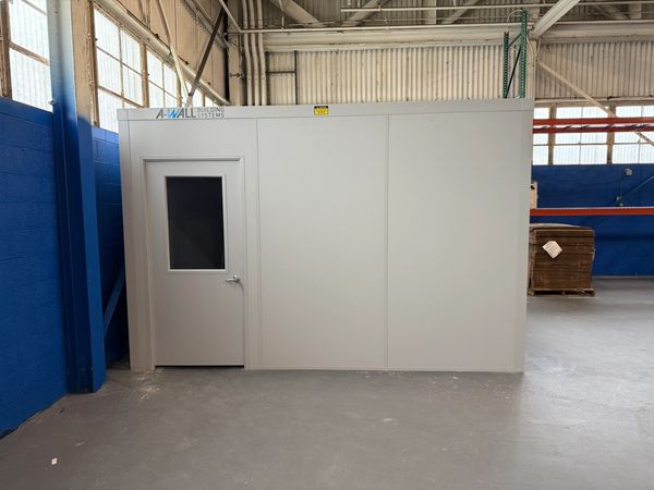 In-front a new modular office solutions installations by SoFlo, with a door, inside a warehouse sett
