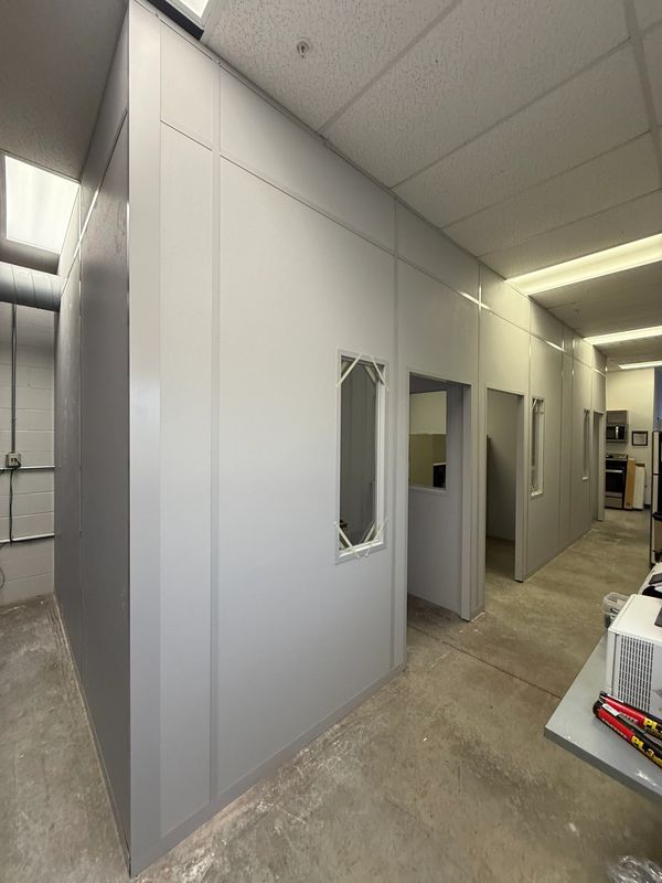 Grey from floor to ceiling modular installations designs by SoFlo, with several windows, doors
